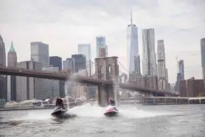 a small boat in a body of water with a city in the background