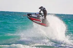 a man flying through the air while riding a wave in the ocean