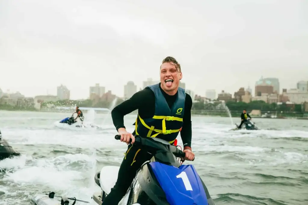 a man smiling next to a body of water