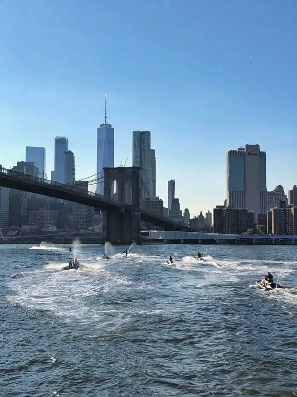Jet skis on the Hudson River with the Brooklyn Bridge and Lower Manhattan skyline