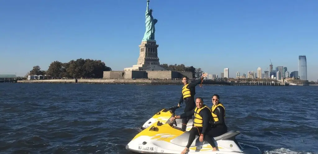 a man riding on the back of a boat in a body of water
