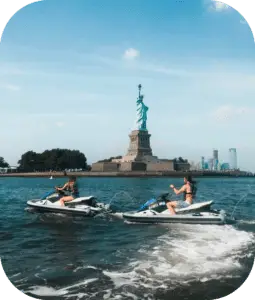 people on jet skis in front of the statue of liberty