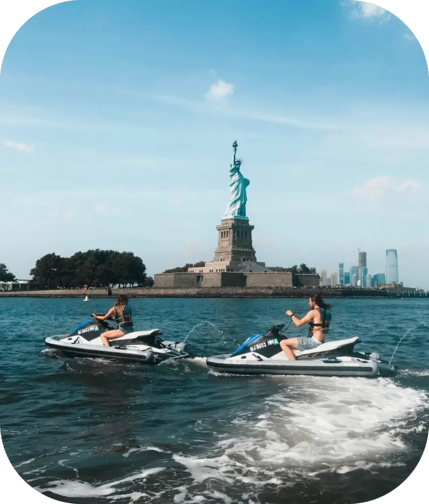 people on jet skis in front of the statue of liberty