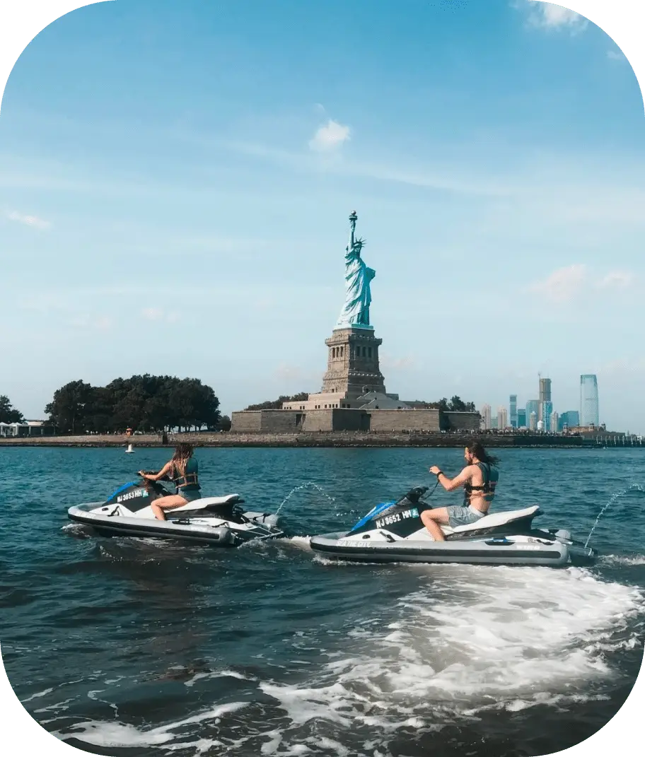 people on jet skis in front of the statue of liberty