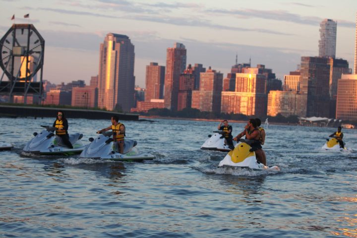 couples riding on jet skis in the sunset