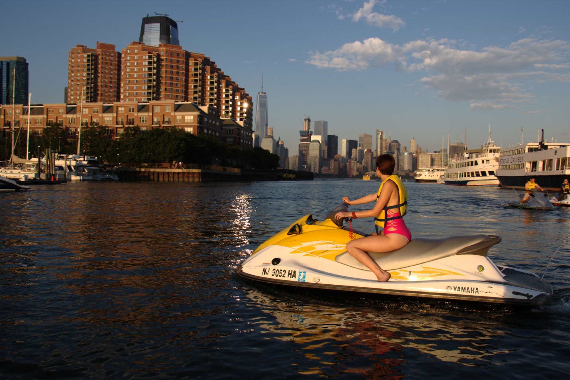 a small boat in a body of water with a city in the background
