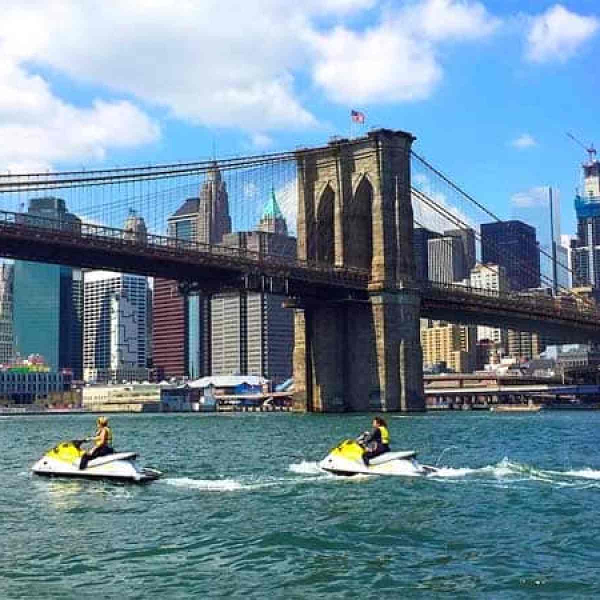 a small boat in a body of water with a city in the background