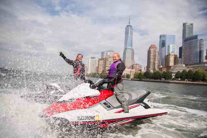 man and woman on separate jet skis in the hudson river