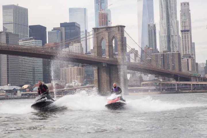 man and woman speeding on jet ski's in nyc