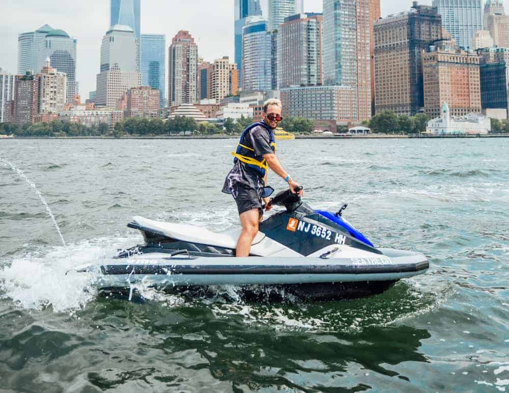 a man riding on the back of a boat in the water