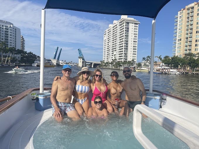 a group of people swimming in the water with a city in the background