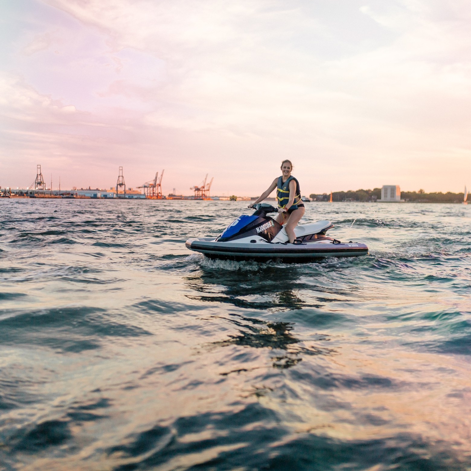 a man riding on the back of a boat in a body of water