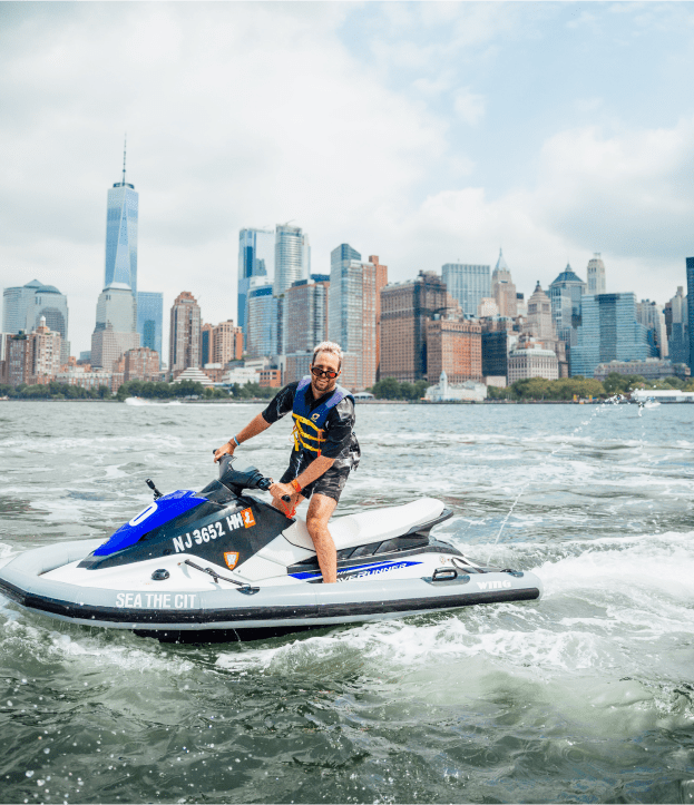 a man riding on the back of a boat in the water