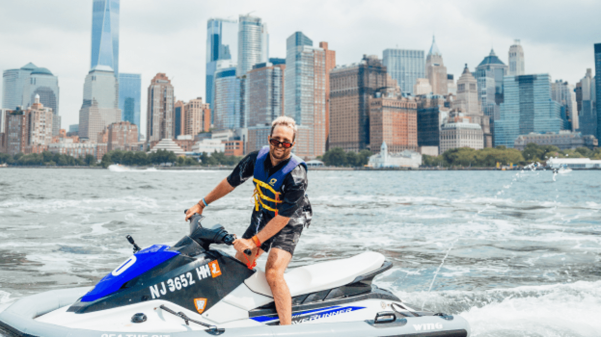 a man riding on the back of a boat in the water