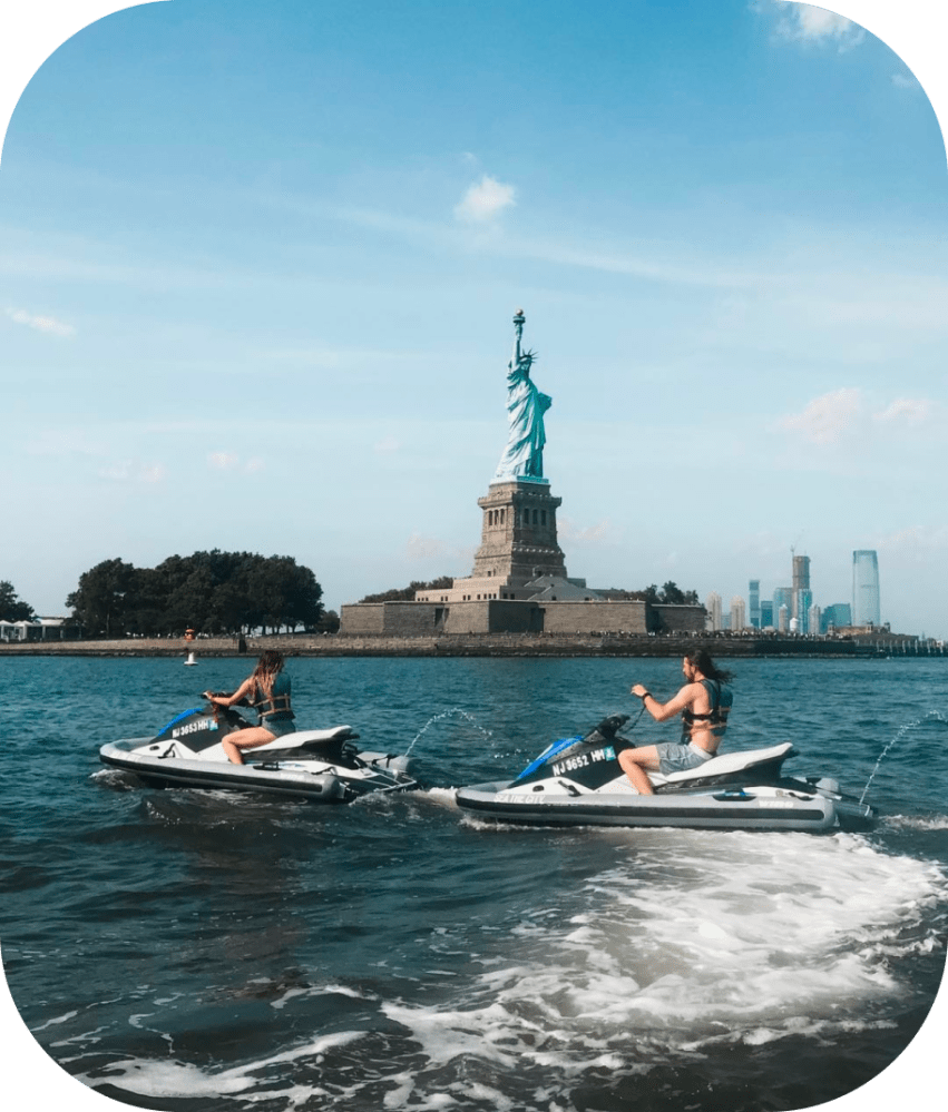 people on jet skis in front of the statue of liberty