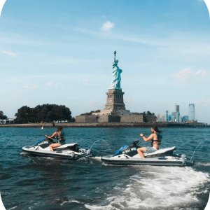 people on jet skis in front of the statue of liberty