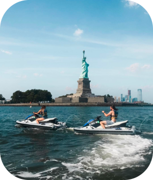 people on jet skis in front of the statue of liberty