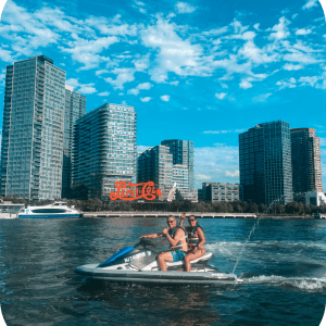 a man swimming in a body of water with a city in the background
