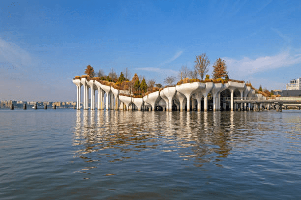 Unique island structure with trees and greenery on pillars, surrounded by calm water.